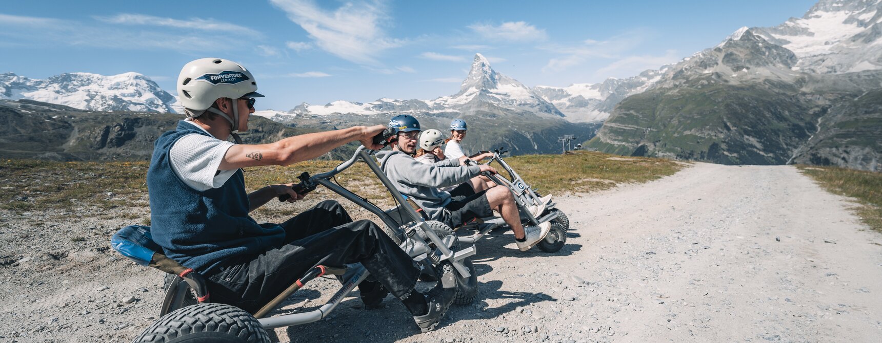 Un gruppo si siede pronto a partire con i loro mountaincarts con il tempo migliore e la vista del Cervino.  | © Gabriel Perren