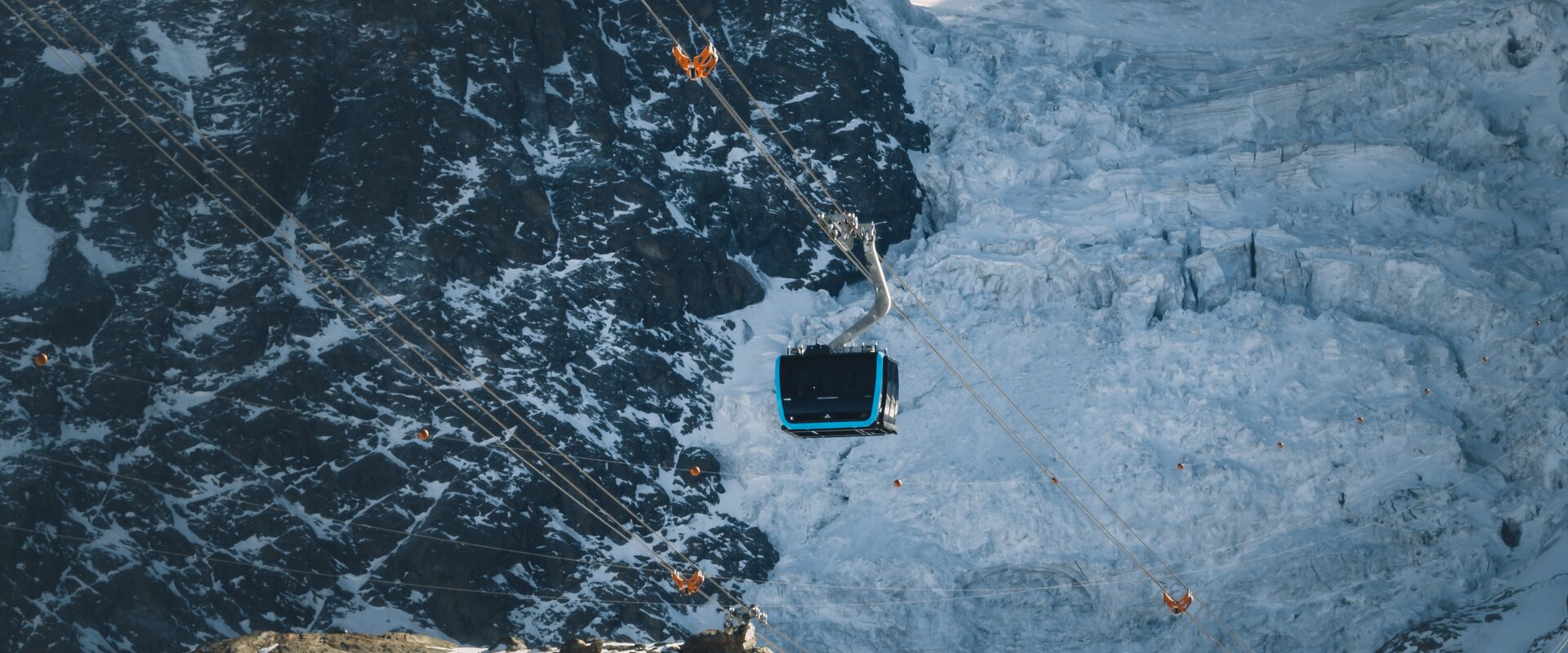 Matterhorn Glacier Ride 1 schwebt über den Theodulgletscher. Eiskluften erscheinen hinter der blauen Gondel.  | © Gabriel Perren 
