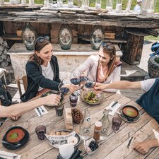 Zwei Päärchen stossen mit einem Glas Rotwein an.  | © Gabriel Perren