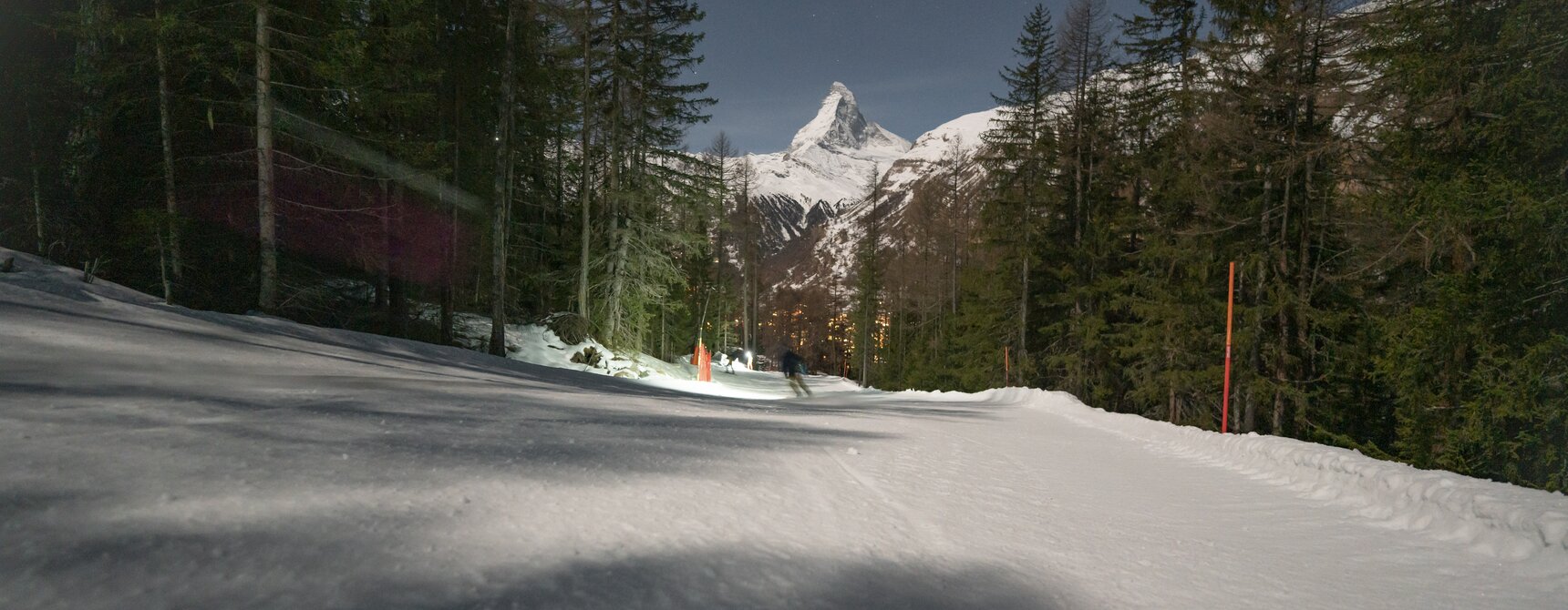 Piste in der Dunkelheit mit einem Skifahrer , das Matterhorn im Hintergrund | © Gabriel_Perren