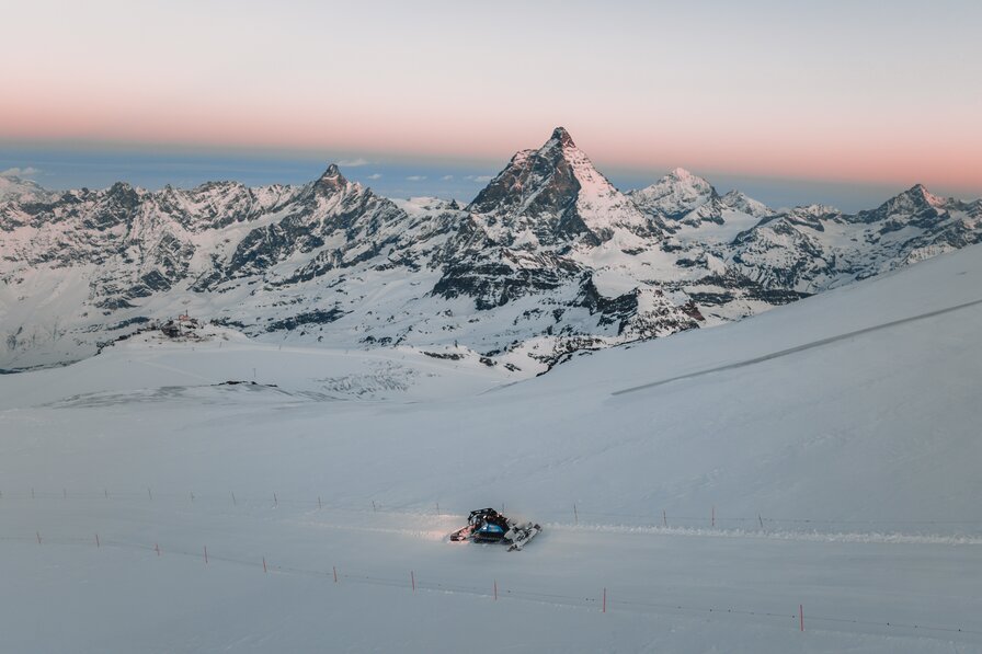 Pistenfahrzeug im Morgenrot in Mitten der Zermatter Gipfel | © Zermatt Bergbahnen