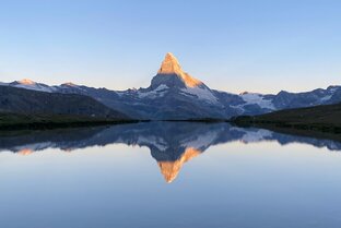 Klassischer Sonnenaufgang mit Spiegelung des Matterhorns mit leuchtendem Gipfel im klaren Stellisee | © Zermatt Bergbahnen