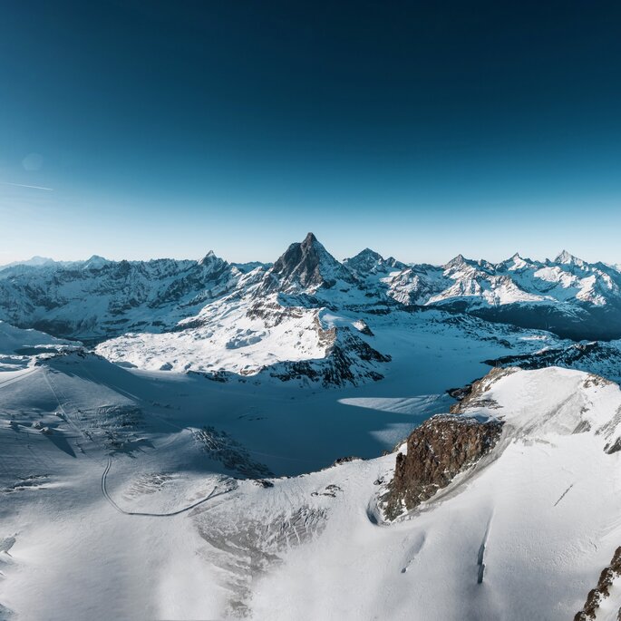Un paesaggio glaciale mozzafiato con una vista su diverse cime di quattromila metri può essere visto sulla traversata alpina del Cervino.  | © Gabriel Perren