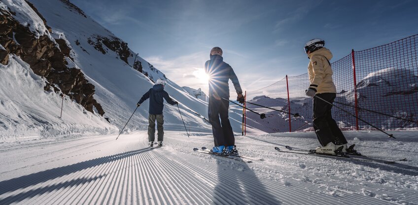 Drei Skifahrer fahren der Sonne entgegen.  | © Zermatt Bergbahnen