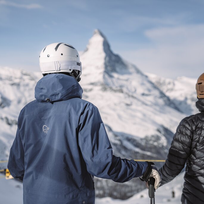 Zwei Gäste geniessen den Ausblick auf das Matterhorn beim Skifahren.  | © Gabriel Perren