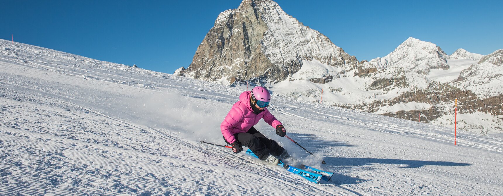 A woman skis and in the background is the Matterhorn | © Michael Portmann