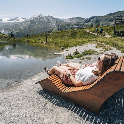 Two people relax on a lounger near the lake Leisee | © Gabriel Perren