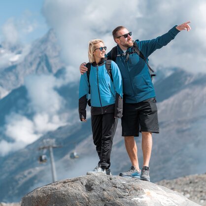 Paar steht auf einem Felsen, im Hintergrund der MEX und die Zermatter Bergwelt | © basic_home