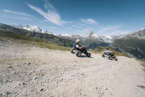 Zwei Männer preschen mit den Mountaincarts den Weg hinunter mit dem Matterhorn im Hintergrund. | © Gabriel Perren